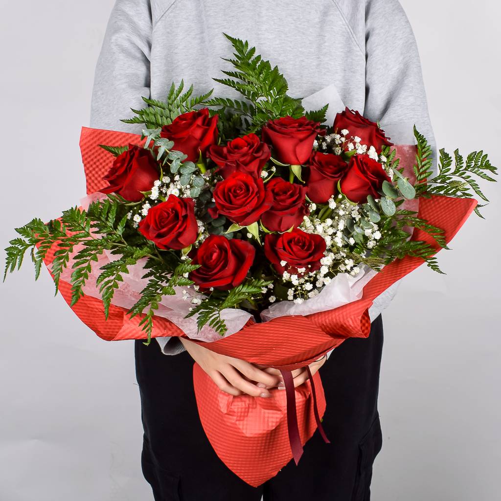 A Dozen Red Roses Hand Tied And Wrapped In Luxury Red Floral Paper